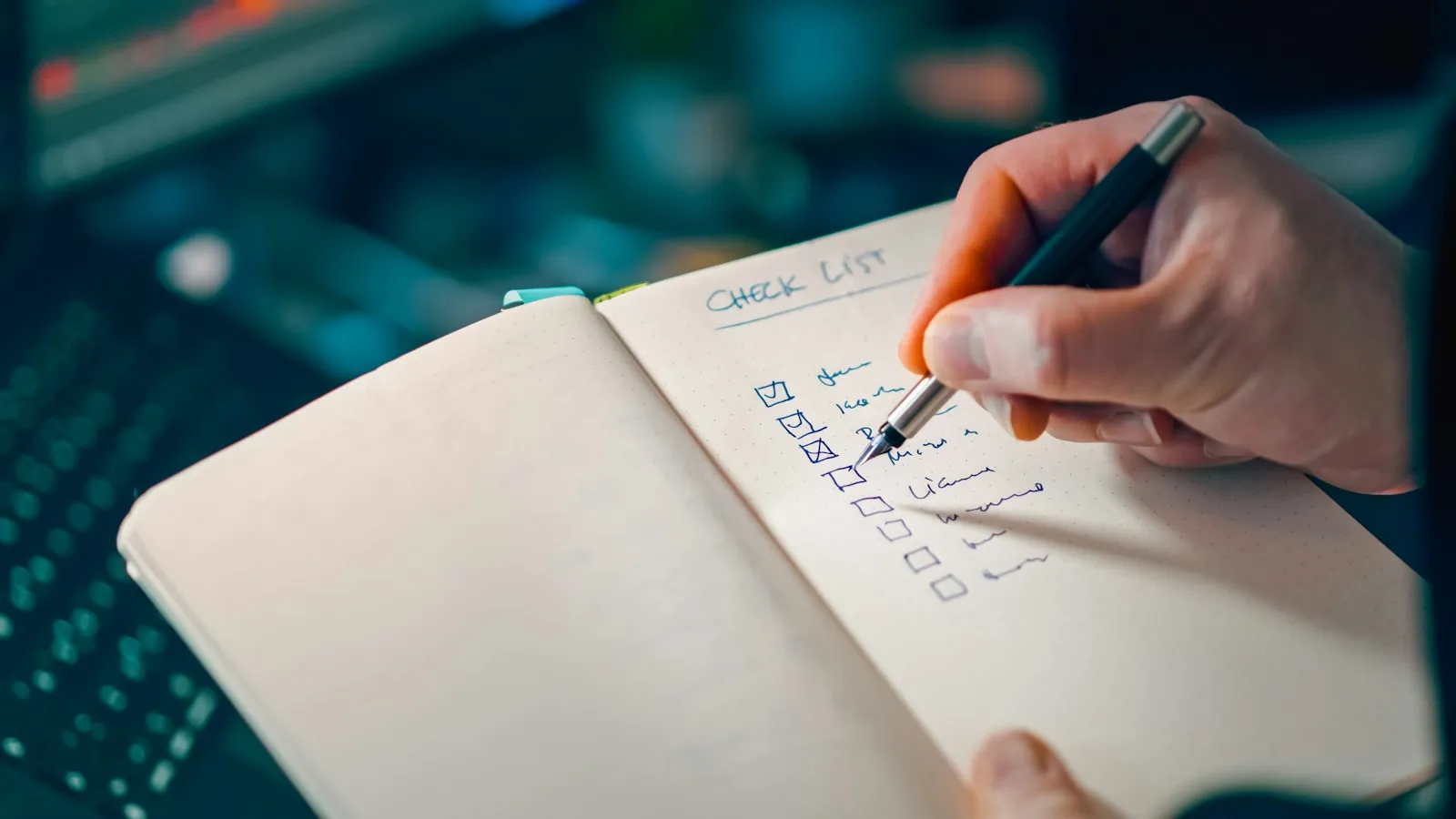 Iemand schrijft met de hand een checklist uit in een notitieboek
